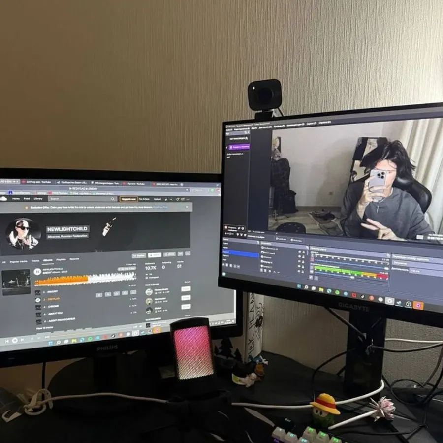 Dual-monitor setup with an artist profile and a video recording session